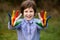 Portrait of cheerful kid girl show hello gesture with hands painted in Seychelles flag colors