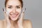 Portrait of cheerful laughing girl applying foam for washing on her face. Lovely woman redhead with attractive appearance. Skin