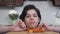 Portrait of a cheerful laughing girl with dark hair and a short haircut fooling around in the kitchen. Funny young woman