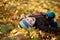 Portrait of a cheerful little boy wallow in fall foliage