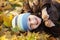 Portrait of a cheerful little boy wallow in fall foliage