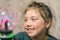 Portrait of a cheerful little girl playing with a plasma ball. The child smiles and laughs while looking at the lightning in a