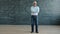 Portrait of cheerful man standing in class with chalkboard wall smiling looking at camera