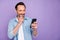 Portrait of cheerful man use cellphone get message from his wife read post enjoy wear casual style clothes isolated over