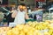 Portrait of a cheerful man in the vegetable department of the supermarket. A funny man holds oranges around the eyes