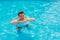 Portrait of a cheerful middle-aged man in the pool with inflatable lifebuoy.