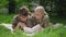 Portrait of cheerful military mother reading book with teenage son lying on sunny meadow in summer spring park. Happy