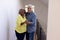 Portrait of cheerful multiracial senior friends dancing by wall in corridor at nursing home