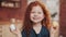 Portrait of cheerful redhead little kid girl playing with easter egg on the kitchen background. She is cheering and