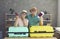 Portrait of a cheerful senior couple leaning on suitcases holding passports and tickets.