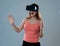 Portrait of cheerful and shocked young woman wearing Virtual Reality headset exploring 3D world