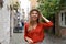 Portrait of cheerful traveler woman walking in Schnoor neighborhood, Bremen, Germany