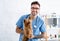 Portrait of cheerful veterinary doc holding cute Yorkshire terrier at animal clinic