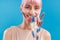 Portrait of cheerful woman with pink hair smiling at camera, holding dried Cortaderia, pampas grass near her face