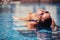 Portrait of cheerful woman relaxing at the luxury poolside.