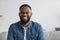 Portrait of cheerful young attractive african american male with beard look at camera in room interior