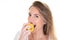 Portrait of cheerful young blonde woman eating bitting yellow apple