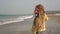 Portrait of a cheerful young hippie downshifter girl with dreadlocks on beach