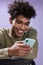 Portrait of cheerful young man messaging on phone and smiling. Transgender afroamerican male