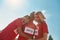 Portrait of cheerful young professional female runners wearing t shirts with number standing together, ready for the