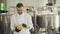 Portrait of a cheesemaker worker holding cheese and smiling at camera. Craft cheese production technology.