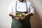 portrait of a chef holding a dish of saag aloo