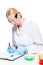 portrait of a chemist in a protective uniform at the table working with test tubes