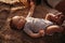 Portrait of a child 4 months old lying on the bed and looking. Charming child with dark eyes lying on back, portrait of baby boy