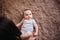 Portrait of a child 4 months old lying on the bed and looking. Charming child with dark eyes lying on back, portrait of baby boy