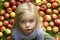 Portrait of child blond young girl with apples background