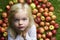 Portrait of child blond young girl with apples background