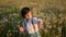 portrait of a child a boy of five years old playing dandelions like drums on a field at sunset.