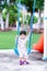 Portrait of child boy playing swinging blue on the playground near the house in the morning.