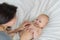 Portrait of a child four months on the bed with mom