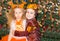 Portrait of child girl and boy in a suit squirrels around a Christmas tree decorated. Kids on holiday new year