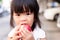 Portrait of child girl eating red apple and looking at camera. Head short of healthy kid eating fresh fruit for snack time.