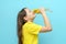 Portrait of a child girl with flowers dandelions in hands on a blue background. The teenager sniffs flowers and closes