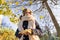 Portrait of child girl under maple tree, background autumn sunny park