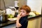 Portrait of child in kitchen. Cute little boy, playing in kitchen. Young kid is hungry, looks at and checks is it finished lunch.