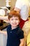 Portrait of child in kitchen. Cute little boy, playing in kitchen. Young kid is hungry, looks at and checks is it finished lunch.