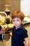 Portrait of child in kitchen. Cute little boy, playing in kitchen. Young kid is hungry, looks at and checks is it finished lunch.