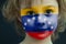 Portrait of a child with a painted Venezuelan flag