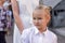 Portrait of a child, school, first grader, with a pretty face, 7 years old, European, blonde, in a white blouse