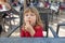 Portrait of child sitting in exterior bar eating cheese puff