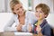 Portrait, child and teacher with thumbs up in classroom, smile and pencil. Happiness, educator and student with hand