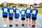 Portrait Of Children On Athletics Track Wearing Competitor Numbers On Sports Day