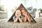 Portrait, children and cardboard for insurance with girl sisters on the floor of the living room at home. Security