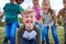 Portrait Of Children On Outdoor Activity Camping Trip Pulling Faces Having Fun Playing Game Together