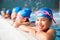 Portrait Of Children In Water At Edge Of Pool Waiting For Swimming Lesson