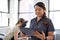 Portrait of a Chinese woman massage therapist holding a tablet while filling the file of an attractive blond client at